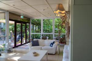 a living room with white furniture and large windows at B&B Santiago in Milano Marittima