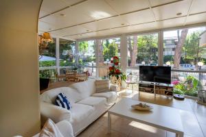 a living room with a white couch and a tv at B&B Santiago in Milano Marittima