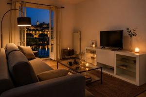 a living room with a couch and a television at Au Fil de L eau in Albi