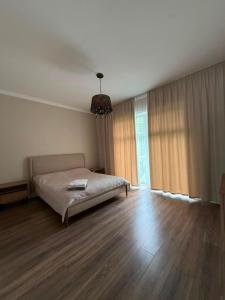 a bedroom with a bed and a wooden floor at Карвен коттедж in Bulan Sogottuu