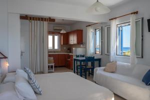 a living room with a large bed and a kitchen at Almira Studios in Kionia