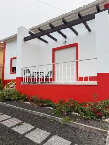 a red and white house with a red and white fence at Montejunto Escape in Cadaval