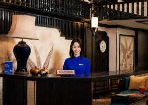 a woman standing behind a counter in a room at Golden Amour Hotel in Hanoi +59 photos