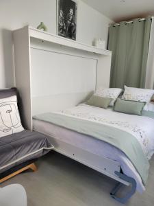 a bedroom with a bed and a chair at Studio cosy Climatisation, terrasse privée, parking devant la maison in Nevers