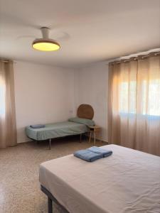 a bedroom with a bed and a window and a bed at Cala Queralt Rooms in Sagunto +11 photos