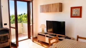 a living room with a television and a balcony at Residenza Paradiso in Agra