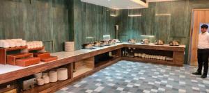 a man standing in front of a counter in a restaurant at Hotel Raaj Palace in Agra