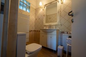 a bathroom with a toilet and a sink and a mirror at Catherine's Seaside House A in Stomio