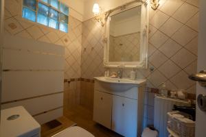 a bathroom with a sink and a mirror and a toilet at Catherine's Seaside House A in Stomio +15 photos