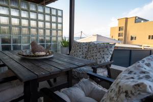 a wooden table on a balcony with a bird on it at Catherine's Seaside House A in Stomio
