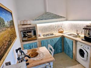 a kitchen with blue cabinets and a wooden table at B&B Lu Core Nosciu in Aradeo