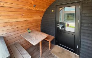 a wooden porch with a wooden table and a door at Awesome Home In Skjern in Skjern