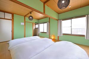 a room with four white pillows on a bed at Shion 潮音 in Sakaide