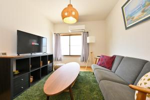 a living room with a couch and a tv at Shion 潮音 in Sakaide