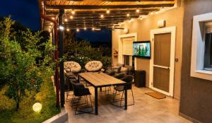 a patio with a table and chairs and a television at Sountou home in Xanthi