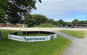 a sign in the grass next to a playground at Beautiful Home In Skjern in Skjern