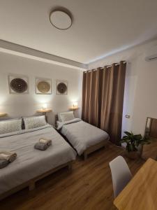 ein Schlafzimmer mit zwei Betten und einem Tisch in der Unterkunft Civico181 in Cisterna di Latina