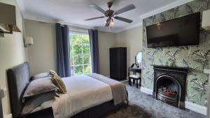 a bedroom with a bed with a fireplace and a flat screen tv at Midway Guest House in Torquay