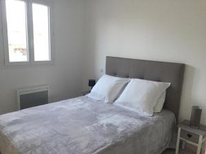 a bedroom with a large bed with white sheets and pillows at Résidence San Pancraziu in LʼÎle-Rousse