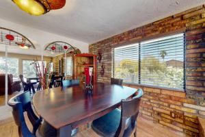 a dining room with a wooden table and a brick wall at Tranquil Trail #8 in Carefree