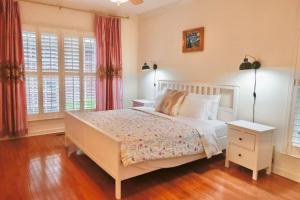 a bedroom with a white bed and two windows at Elegant Suite King Bed, Queen Sofa, Fast WiFi in Fayetteville