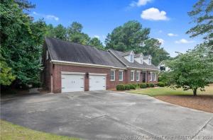 a red brick house with a driveway in front of it at Elegant Suite King Bed, Queen Sofa, Fast WiFi in Fayetteville