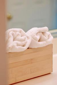 a white towel sitting on top of a wooden box at Elegant Suite King Bed, Queen Sofa, Fast WiFi in Fayetteville +55 photos