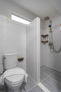 a white bathroom with a toilet and a shower at The Comfy House Prachuap in Sathani Rot Fai +21 photos