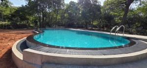 a swimming pool with a fountain in a yard at Tamarind Tamarind Resort, Tourist Board Approved in Habarana