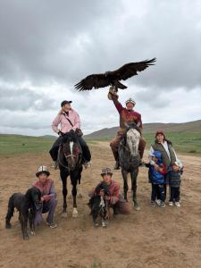 a group of people on horses with an eagle at Guesthouse Arnas in Bokonbayevo