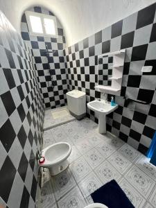 a bathroom with a black and white checkered wall at Maison vue mer in Rafrāf
