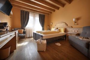 a bedroom with a bed and a couch and a kitchen at Bio Hotel Villa Cecilia in Livigno