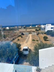 a car parked in a parking lot next to the beach at Maison vue mer in Rafrāf +3 photos