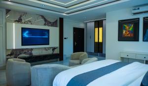 a bedroom with a bed and a tv on a wall at Ocean Front Hotels Enugu in Awkuzu +22 photos