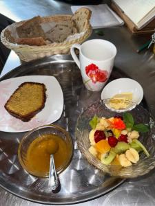 a table with a plate of food and a bowl of fruit at Chambre Panoramique Bellevue in Bellegarde-Adoulins