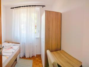 a small room with a bed and a window at Apartma Breza in Kojsko