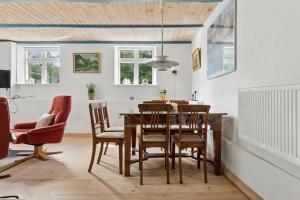 a dining room with a wooden table and chairs at Charming 45 M House In Peaceful Setting in Gelsted