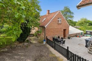 a house with a fence next to a patio at Charming 45 M House In Peaceful Setting in Gelsted +7 photos