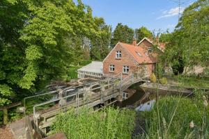 a bridge over a river with a house on it at Charming 45 M House In Peaceful Setting in Gelsted