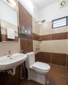 a bathroom with a white toilet and a sink at Urban Escape in Cochin