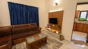 a living room with a couch and a television at Urban Escape in Cochin