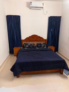 a bedroom with a bed with blue curtains at Urban Escape in Cochin