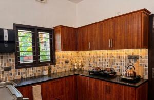 a kitchen with wooden cabinets and a counter top at Urban Escape in Cochin