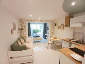 a kitchen and living room with a couch and a table at Studio calme avec terrasse et piscine in Saint-Vallier-de-Thiey