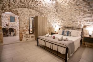 a bedroom with a bed and a stone wall at Mainotti's house in Areopoli