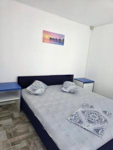 a bedroom with a bed and two blue tables at Holiday Village in Eforie Nord