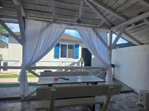 a picnic table under a pavilion with a white curtain at Holiday Village in Eforie Nord