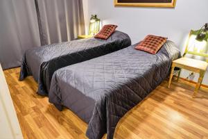 two beds sitting in a room with a chair at Cozy two-room apartment with sauna in Sodankylä