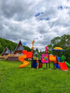 grupa urządzeń zabawowych na trawiastym boisku w obiekcie Romulus A-Frame w mieście Greşu