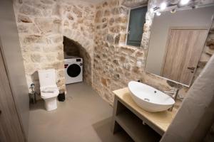 a stone bathroom with a sink and a toilet at Mainotti's house in Areopoli +19 photos